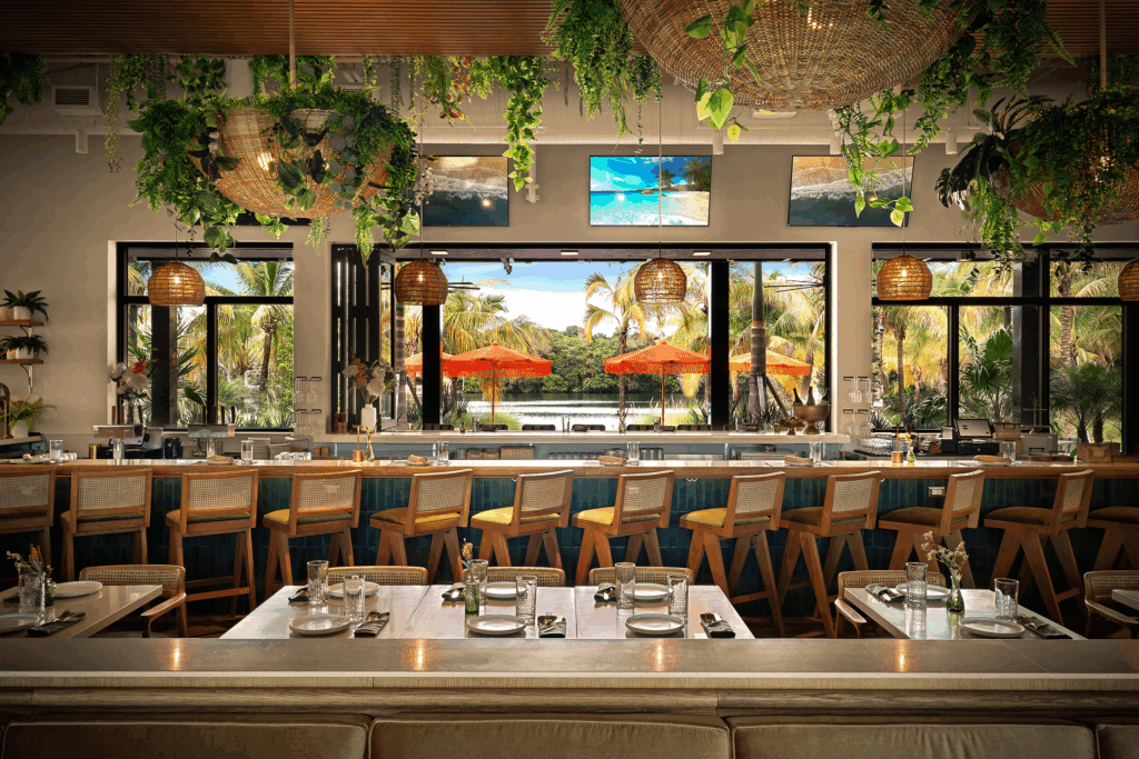 Indoor-outdoor dining at Florida Room in Fort Lauderdale with lakefront views, bar seating, and tropical atmosphere.