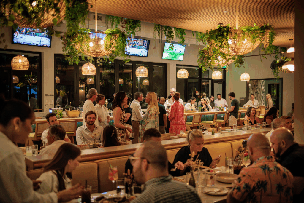 Busy dinner scene at Florida Room Fort Lauderdale with guests dining, bar crowd, and lively restaurant atmosphere.