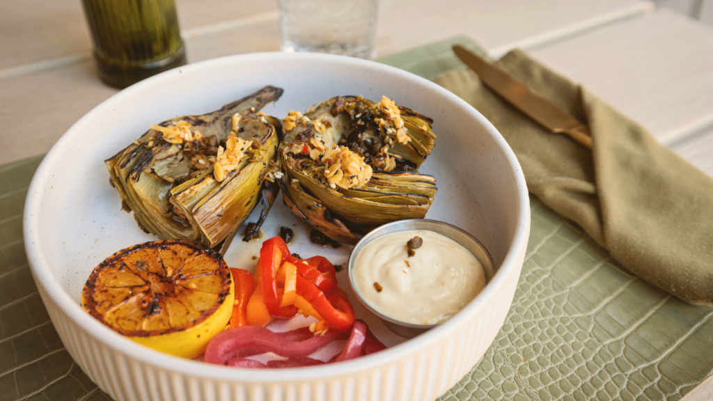 Grilled artichokes with charred lemon, peppers, and creamy dipping sauce at Florida Room Fort Lauderdale