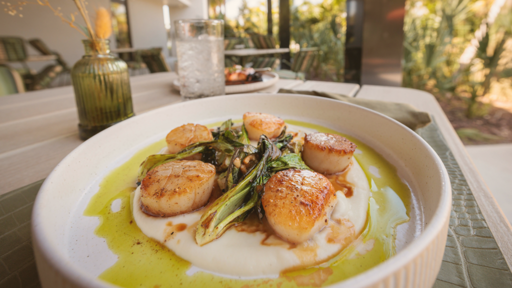 Seared scallops over creamy puree with greens and olive oil at Florida Room Fort Lauderdale