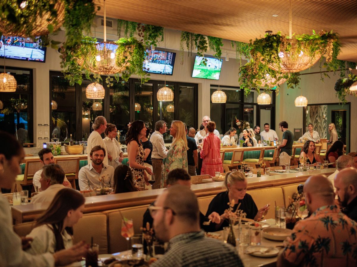 Guests dining inside Florida Room restaurant with bar seating and warm lighting in Fort Lauderdale