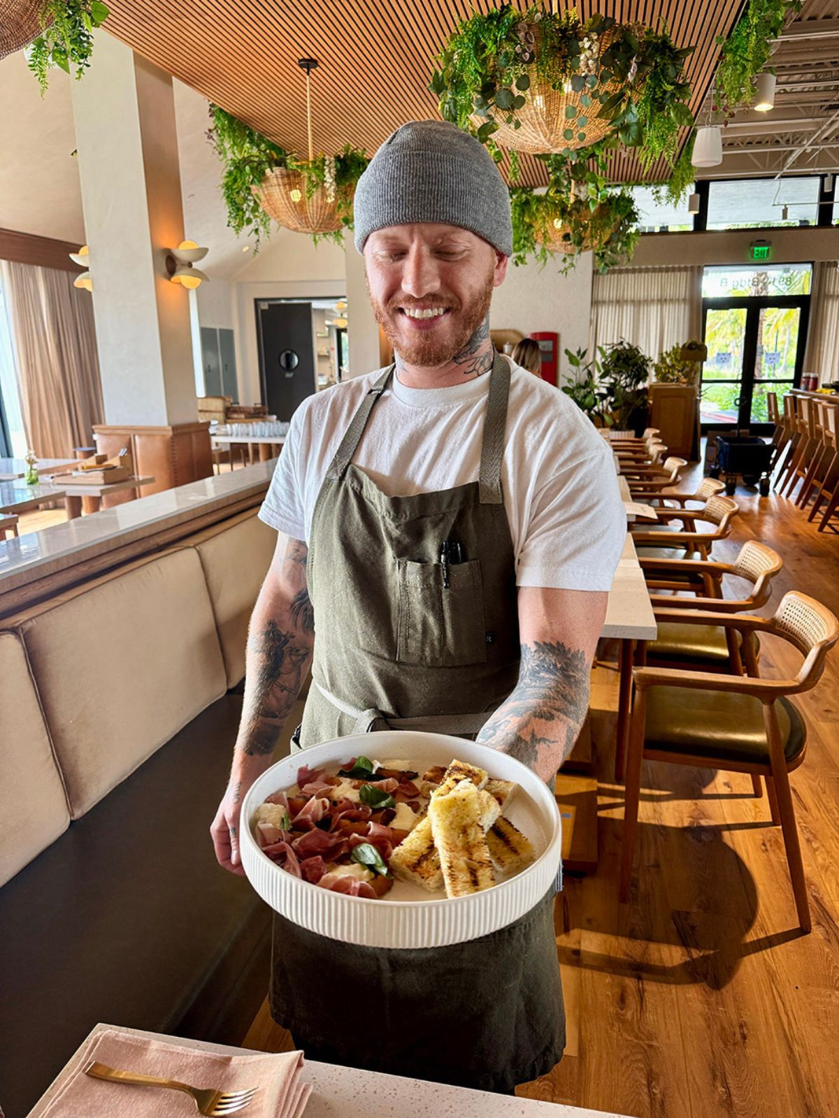 Chef presenting a plated dish inside Florida Room restaurant