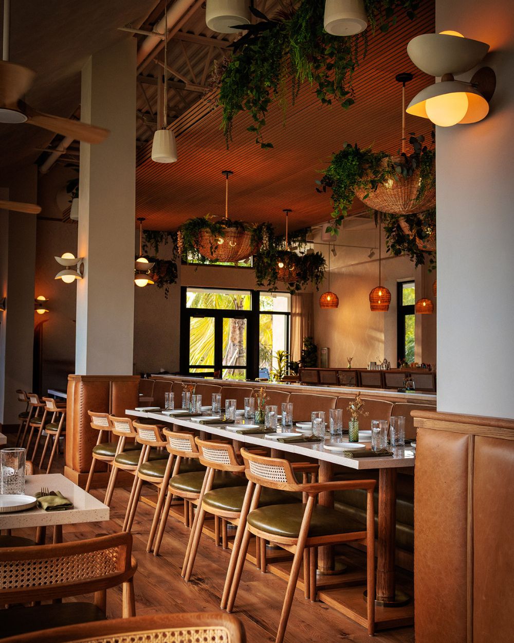 Dining room interior with wood tables and hanging plants at Florida Room