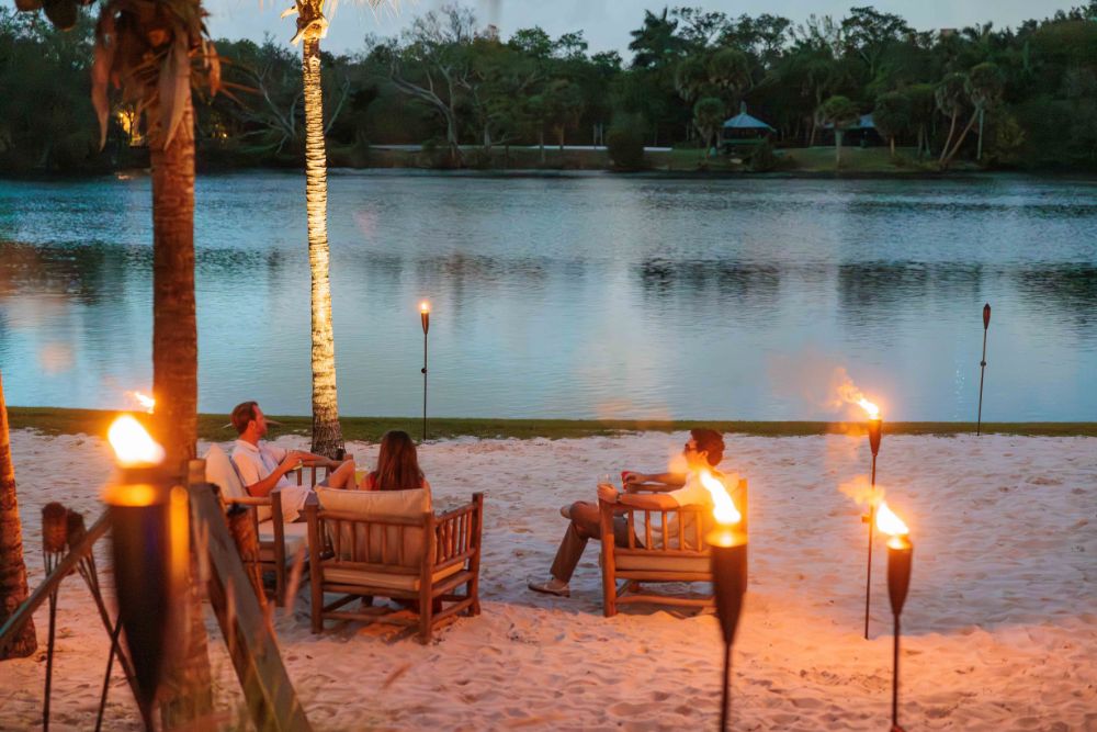 Florida Room Lakeside Beach Seating at Night Lakeside beach seating with tiki torches at Florida Room in Fort Lauderdale