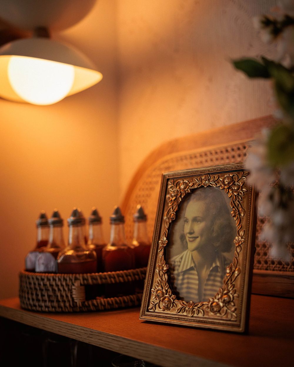Vintage framed photo with warm lamp lighting and bottles at Florida Room