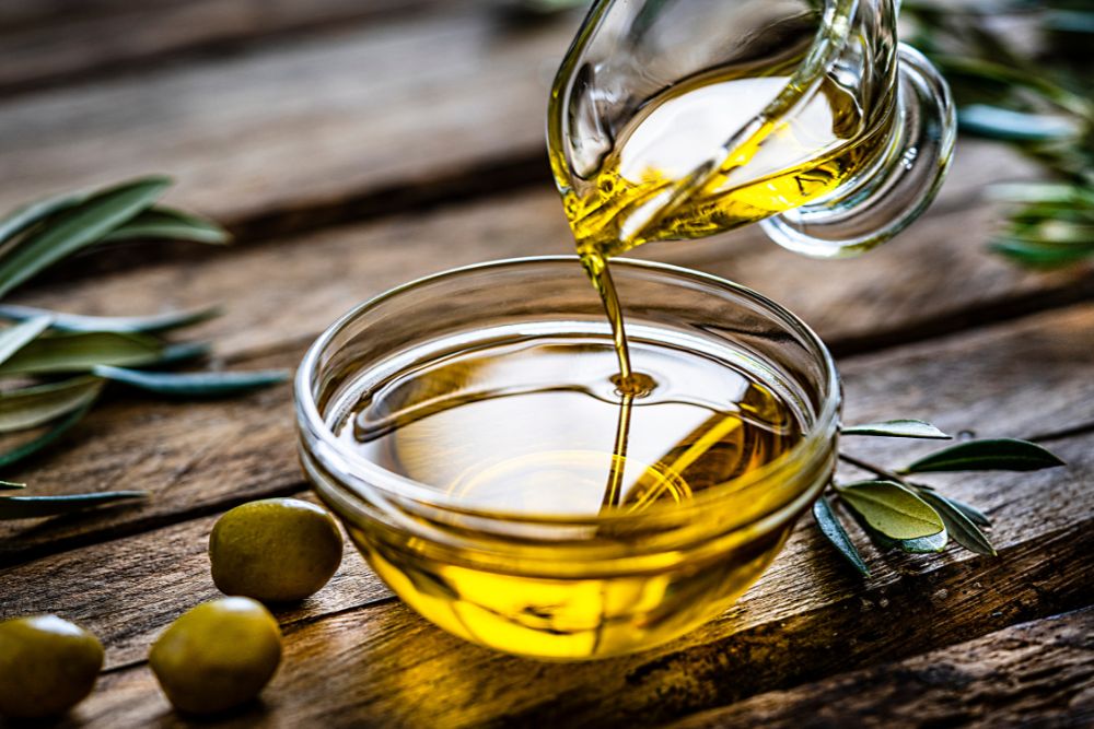 Olive oil being poured into a bowl representing Florida Room’s seed oil free cooking