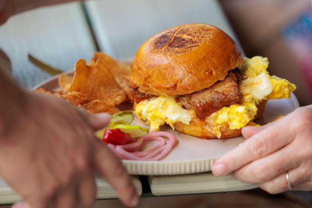 Breakfast sandwich with scrambled eggs, bacon, and house-made chips served during brunch at the Florida Room in Fort Lauderdale.