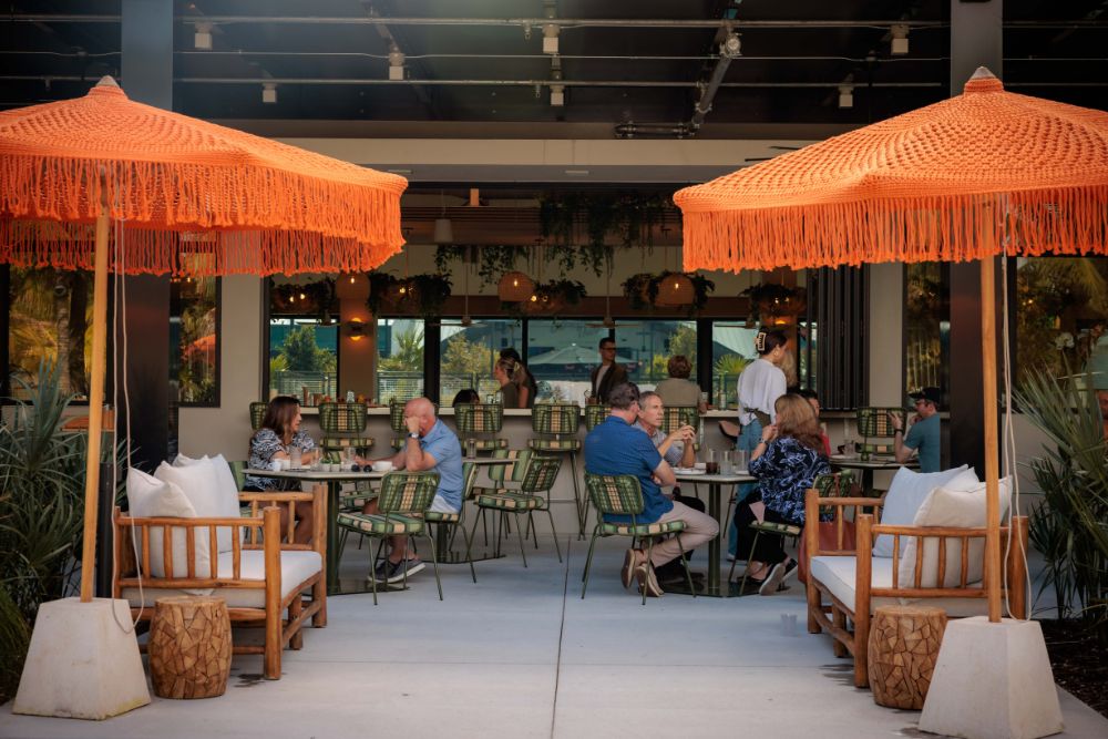 Guests enjoying brunch on the outdoor lakeside patio at the Florida Room in Fort Lauderdale.